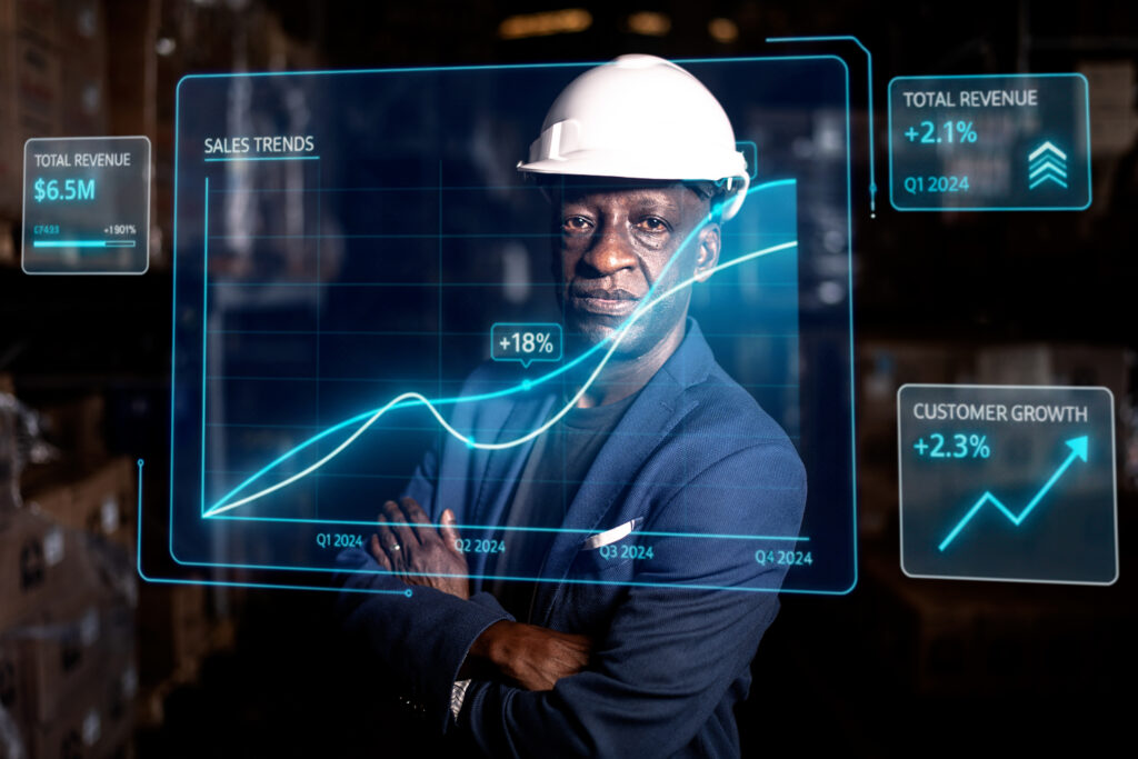 Man in hard hat with digital graphs, showcasing industrial AI consulting sales trends and growth.