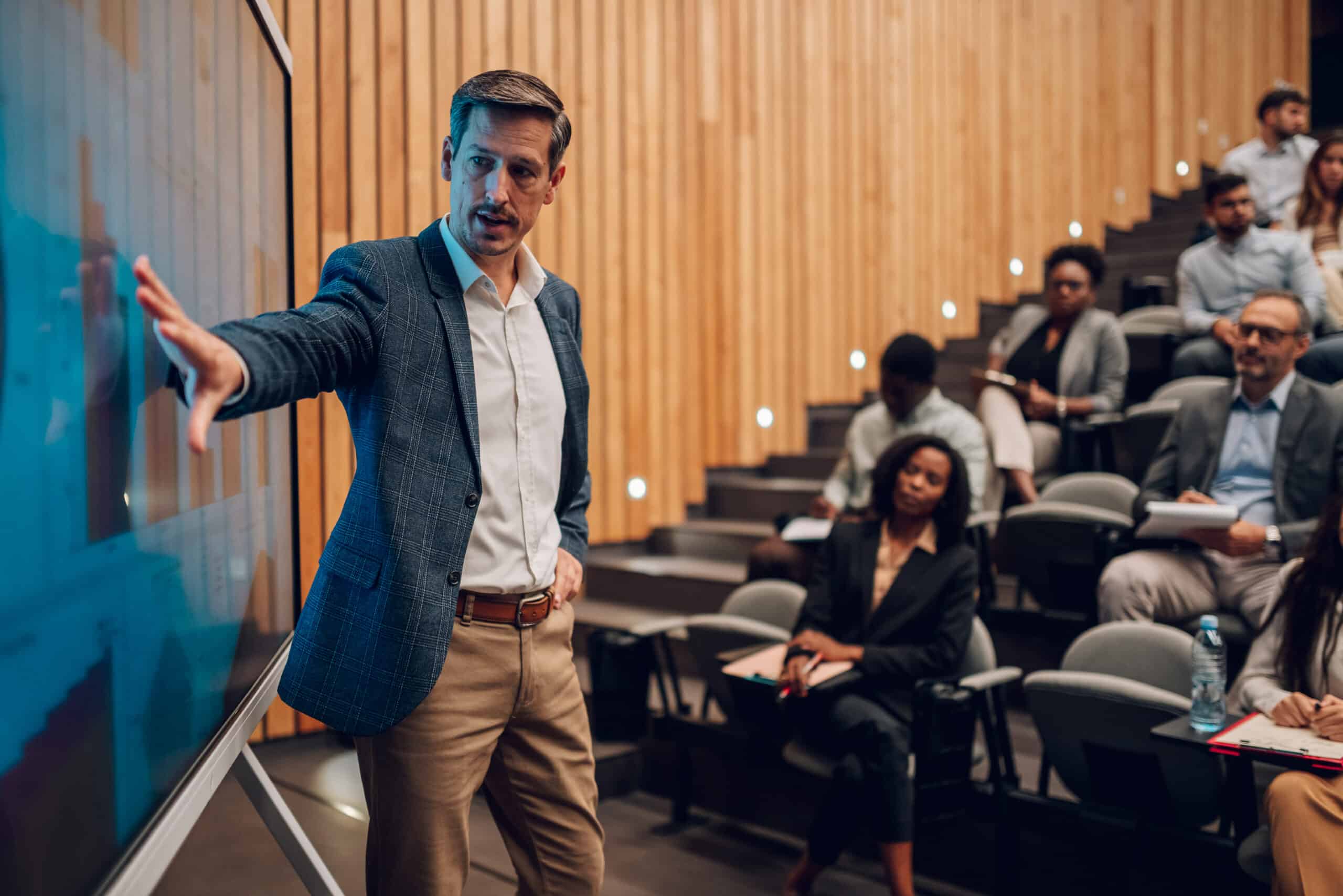 Businessman speaking in front of audience on people analytics consulting