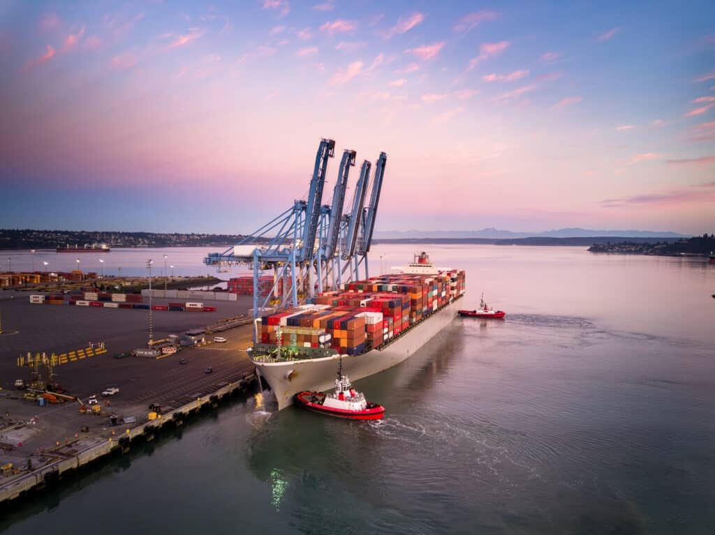 Tariff Ready Supply Chains boost efficiency as cargo ships dock with cranes at sunset.