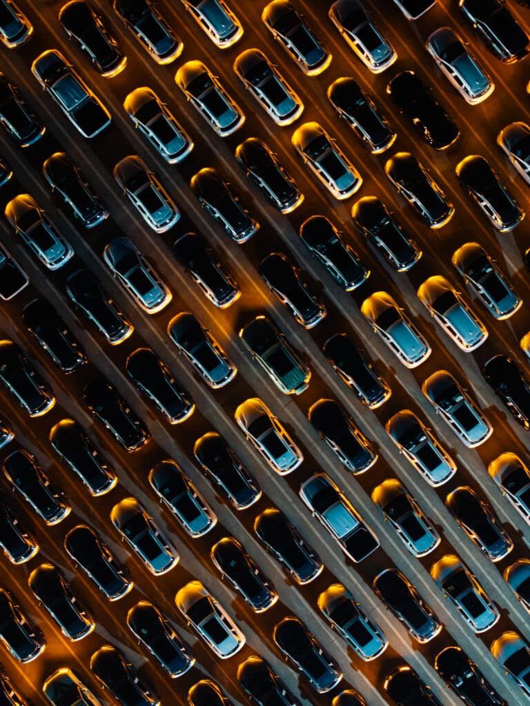 Aerial view of parked cars, illuminated by streetlights, reflects Product Lifecycle Management.