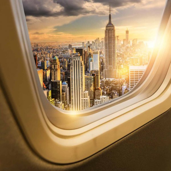 View of New York City skyline through an airplane window at sunset—aviation advisory services.