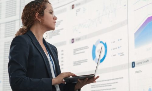 Businesswoman using laptop exploring Modern Data Architecture consulting services.